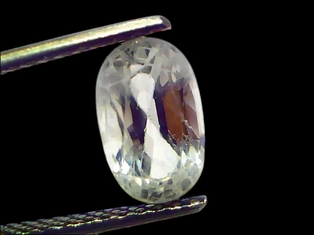 2.95 Ct Gii Certified Unheated Untreated Natural Ceylon White Sapphire held by tweezers, showcasing its clarity and brillianc