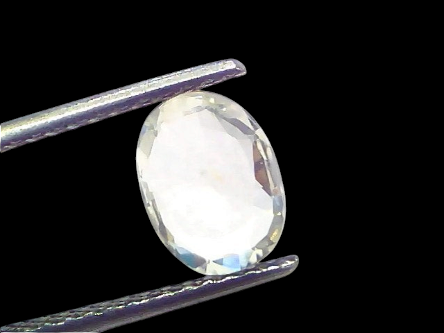 Oval-cut 2.18 Ct certified unheated untreated natural Ceylon white sapphire held by tweezers against a light background.