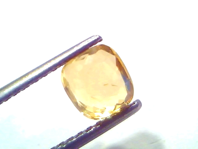 Natural Ceylon yellow sapphire held by tweezers, showcasing its vibrant yellow hue and cushion cut. 2.02 Ct.