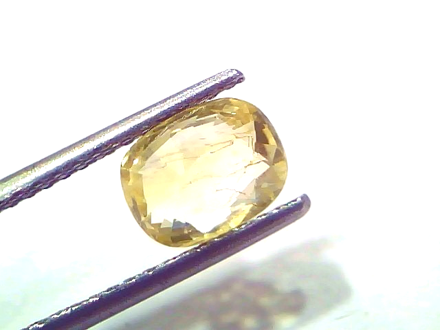 2.06 Ct Certified Unheated Natural Ceylon Yellow Sapphire Pukhraj held by tweezers, showcasing its vibrant yellow hue and cla