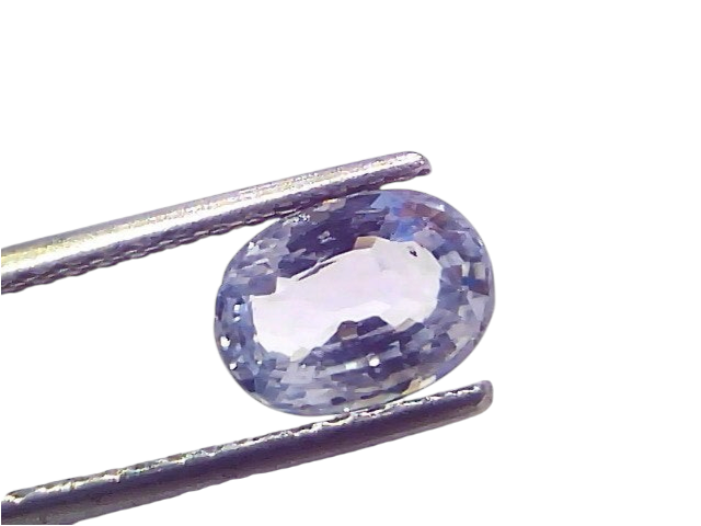 Oval-shaped 2.05 carat unheated natural Ceylon blue sapphire held by tweezers, showcasing its vibrant blue hue and brilliance