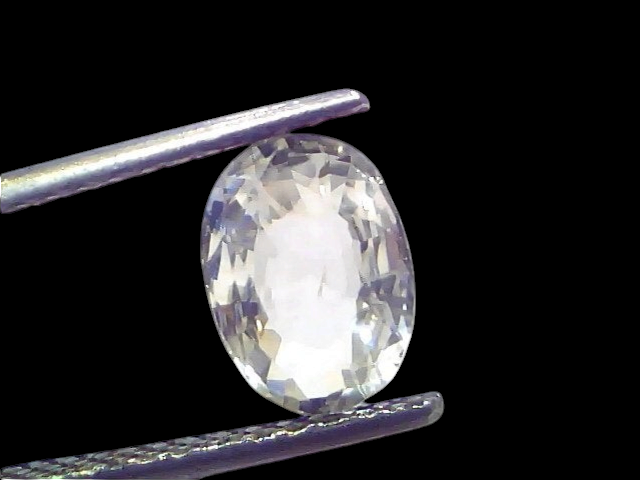 Oval-cut 2.18 Ct certified unheated untreated natural Ceylon white sapphire held by tweezers against a light background.