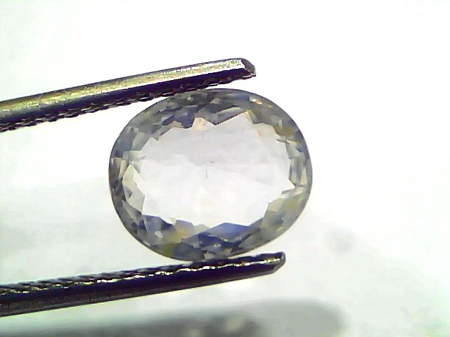 3.11 Ct Gii Certified Unheated Untreated Natural Ceylon White Sapphire, oval cut, held with tweezers against a light backgrou