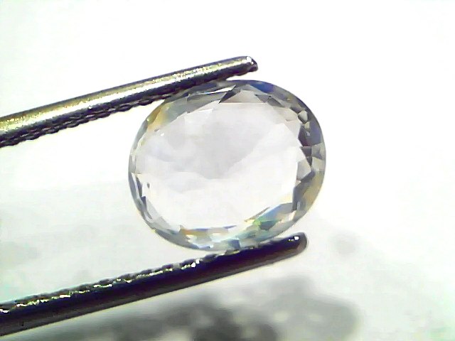 3.11 Ct Gii Certified Unheated Untreated Natural Ceylon White Sapphire, oval cut, held between tweezers, showcasing clarity a