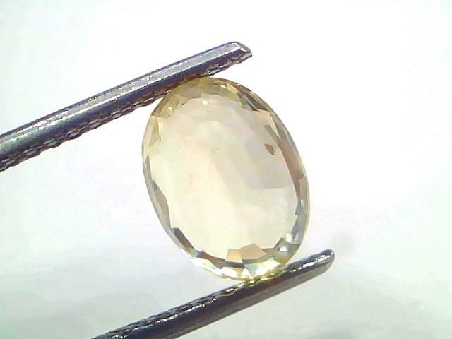 Venus Gems 3.39 carat unheated natural Ceylon yellow sapphire in an oval mixed cut held by tweezers