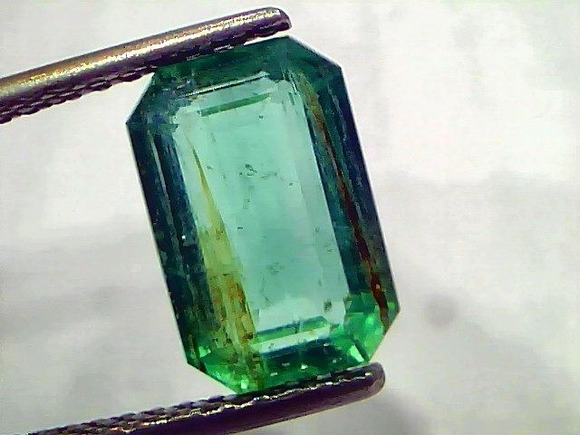 3.76 Carat Certified Natural Zambian Emerald, untreated, with a rectangular cut and vibrant green color, held by tweezers.