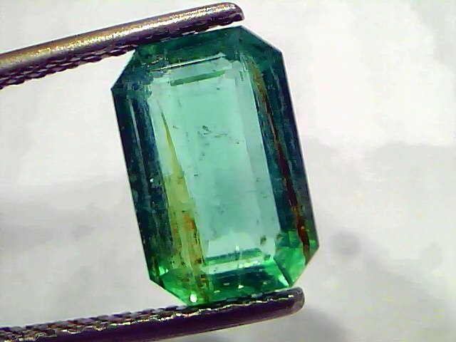 3.76 Carat Certified Natural Zambian Emerald, untreated, with a rectangular cut and vibrant green color, held by tweezers.