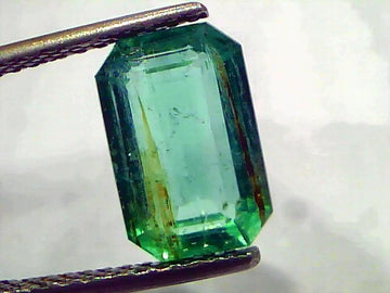3.76 Carat Certified Natural Zambian Emerald, untreated, with a rectangular cut and vibrant green color, held by tweezers.