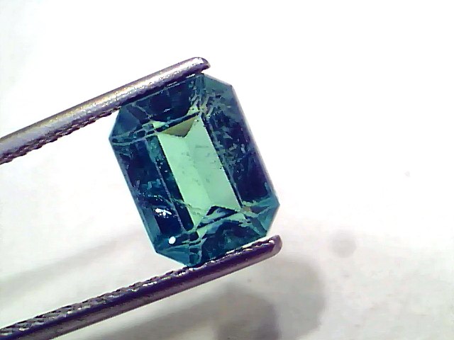 3.80 carat GII certified natural Zambian emerald, untreated, with a vibrant green hue and octagonal cut, held by tweezers.