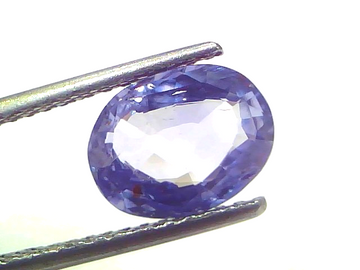 Oval-shaped natural Ceylon blue sapphire, 3.15 Ct, unheated and untreated, displayed with tweezers.