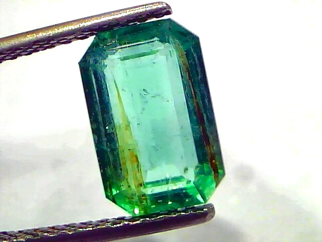 3.76 Carat Certified Natural Zambian Emerald, untreated, with a rectangular cut and vibrant green color, held by tweezers.