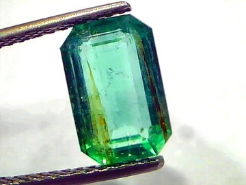 3.76 Carat Certified Natural Zambian Emerald, untreated, with a rectangular cut and vibrant green color, held by tweezers.