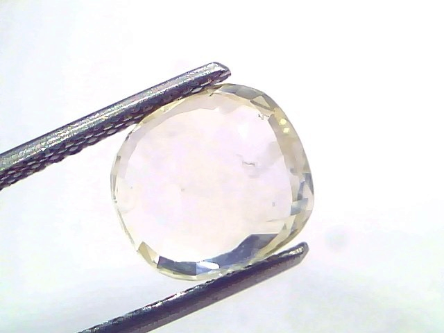 3.89 Ct IGI Certified Unheated Natural Ceylon Yellow Sapphire Pukhraj displayed in tweezers, showcasing its cushion cut and c