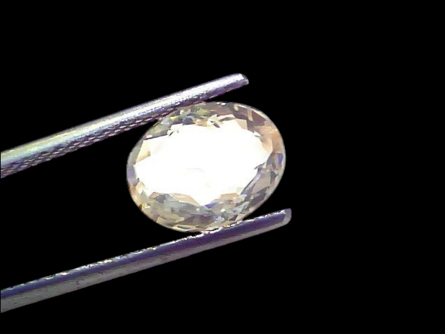 3.52 Ct Certified Unheated Untreated Natural Ceylon White Sapphire held by tweezers, showcasing its clarity and brilliance.