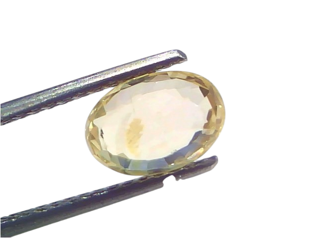 3.14 Ct IGI Certified Unheated Natural Ceylon Yellow Sapphire Pukhraj held by tweezers, showcasing its oval cut and yellow hu