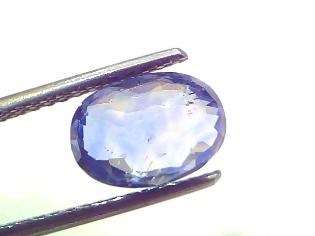 3.48 carat IGI certified unheated natural Ceylon blue sapphire, oval cut, displayed in tweezers against a white background.