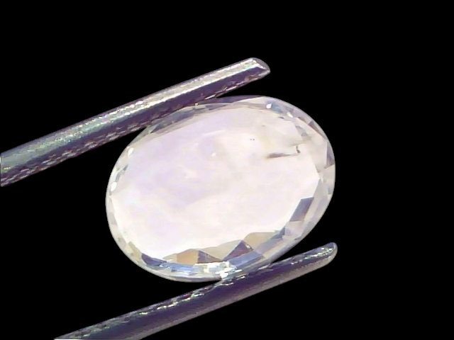 Venus Gems 3.33 carat unheated oval natural Ceylon white sapphire gemstone held in metal tweezers