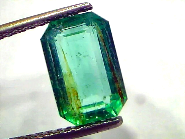 3.76 Carat Certified Natural Zambian Emerald, untreated, octagonal cut, vibrant green color, held by tweezers.