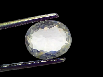 3.11 Ct Gii Certified Unheated Untreated Natural Ceylon White Sapphire, oval cut, held with tweezers against a light backgrou