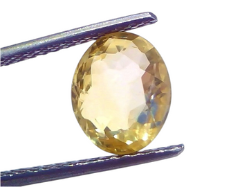 3.53 carat unheated natural Ceylon yellow sapphire in an oval cut, held with tweezers against a light background.
