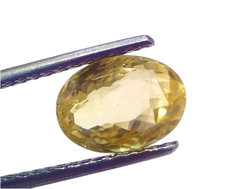 3.57 carat IGI certified unheated natural Ceylon yellow sapphire in a faceted oval cut, held by tweezers.