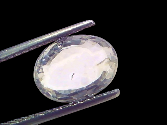 Venus Gems 3.33 carat unheated oval natural Ceylon white sapphire gemstone held in metal tweezers