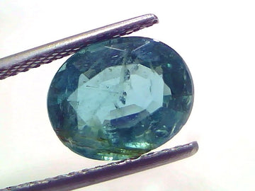 4.10 Carat Certified Natural Zambian Emerald, untreated, oval cut, displayed between tweezers against a white background.
