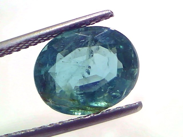 4.10 Carat Certified Natural Zambian Emerald, untreated, oval cut, displayed between tweezers against a white background.