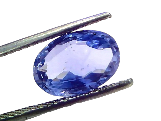 4.46 carat IGI certified unheated natural Ceylon blue sapphire in an oval cut, held with tweezers against a white background.