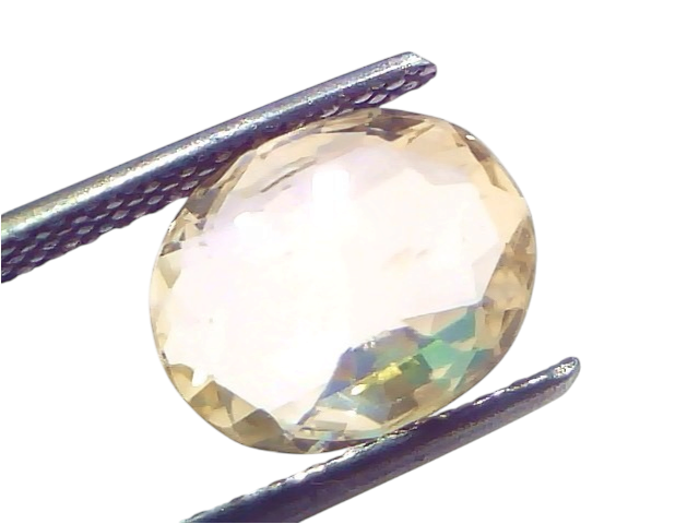 4.00 carat IGI certified unheated natural Ceylon yellow sapphire, oval cut, held with tweezers against a white background.