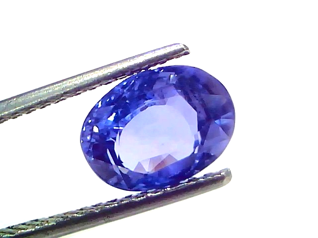 4.09 carat IGI certified unheated natural Ceylon blue sapphire held by tweezers, showcasing its vibrant blue color and brilli