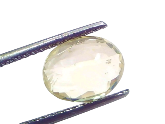 4.07 carat IGI certified unheated natural Ceylon yellow sapphire, oval cut, held with tweezers against a white background.