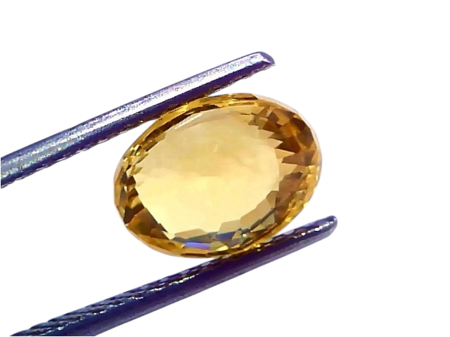 4.18 Ct IGI Certified Unheated Natural Ceylon Yellow Sapphire Pukhraj, oval-shaped, held by tweezers against a white backgrou