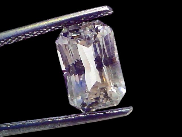 4.09 Ct Gii Certified Unheated Untreated Natural Ceylon White Sapphire, octagonal cut, held by tweezers against a white backg