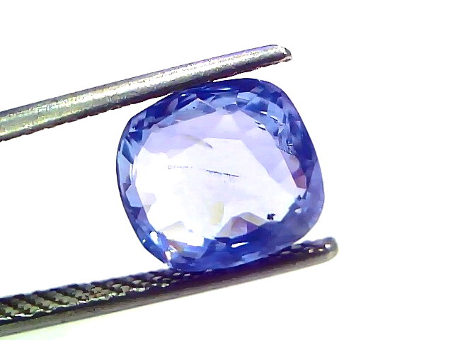 4.49 carat IGI certified unheated natural Ceylon blue sapphire, cushion cut, displayed between tweezers on a white background