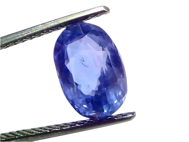5.06 carat IGI certified unheated natural Ceylon blue sapphire, oval cut, displayed between tweezers against a light backgrou