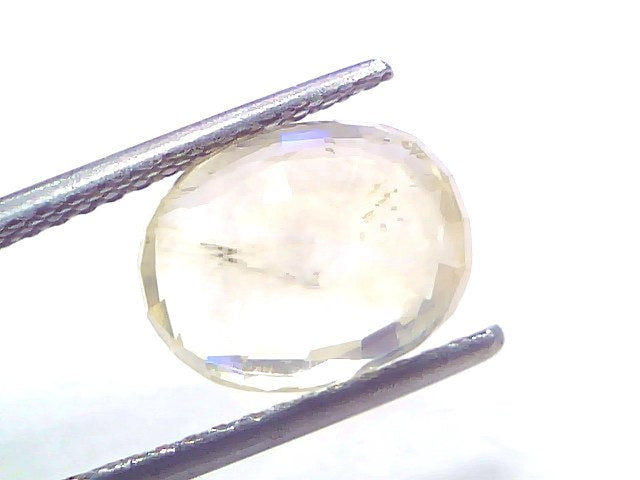 5.71 Ct Certified Unheated Natural Ceylon Yellow Sapphire Pukhraj displayed in tweezers, showcasing its oval cut and yellow h