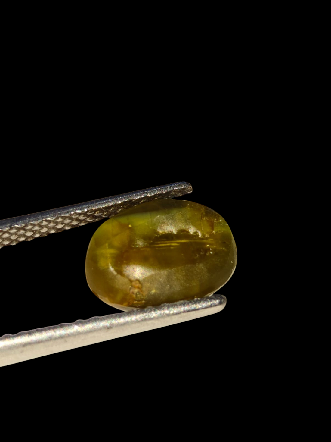 Venus Gems 5.18 carat untreated green chrysoberyl cat's eye gemstone with sharp chatoyancy in an oval cabochon cut.