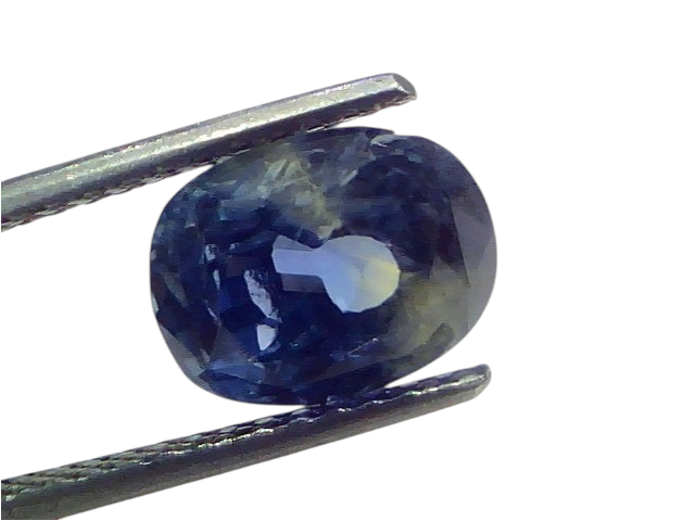 5.07 carat unheated natural Ceylon blue sapphire held by tweezers, showcasing its deep blue color and clarity.