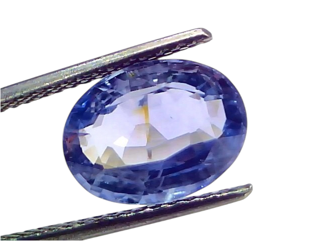 5.78 carat IGI certified unheated natural Ceylon blue sapphire, oval cut, displayed between tweezers on a white background.