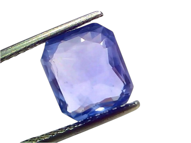 5.54 carat IGI certified unheated natural Ceylon blue sapphire, octagonal cut, held by tweezers against a white background.