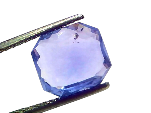 5.32 carat IGI certified unheated natural Ceylon blue sapphire, octagonal cut, held with tweezers against a white background.