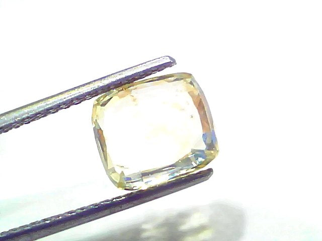 6.07 carat GII certified Ceylon natural yellow sapphire Pukhraj, cushion-cut, held with tweezers against a white background.