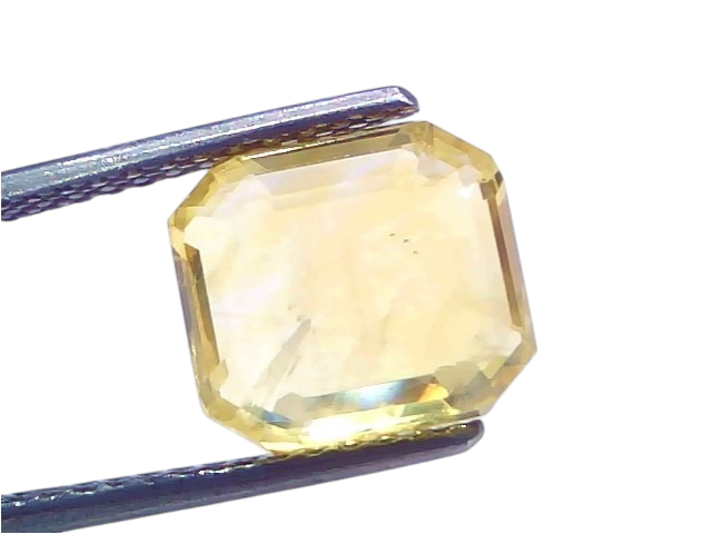 6.61 Ct IGI Certified Unheated Natural Ceylon Yellow Sapphire Pukhraj, octagonal cut, held with tweezers, showcasing its clar