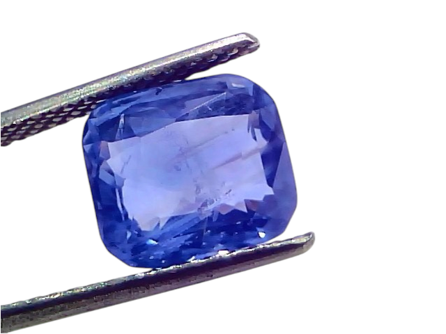 6.12 carat IGI certified unheated natural Ceylon blue sapphire, displayed in tweezers, showcasing its vibrant blue color.