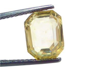 6.11 Ct IGI Certified Unheated Natural Ceylon Yellow Sapphire Pukhraj in an octagonal cut, held with tweezers against a light