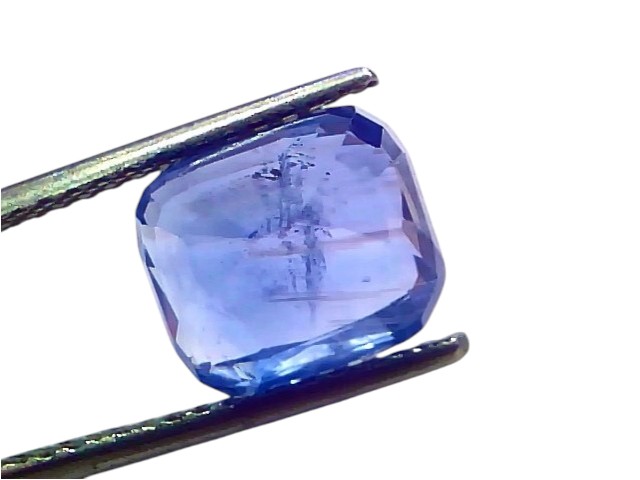 6.12 carat IGI certified unheated natural Ceylon blue sapphire, displayed in tweezers, showcasing its vibrant blue color.