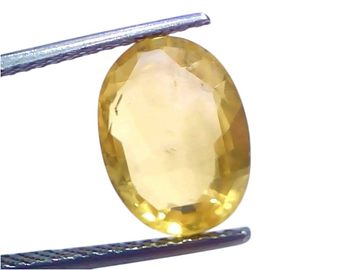 6.13 Ct IGI Certified Unheated Natural Ceylon Yellow Sapphire Pukhraj, oval-shaped, held with tweezers, showcasing its vibran