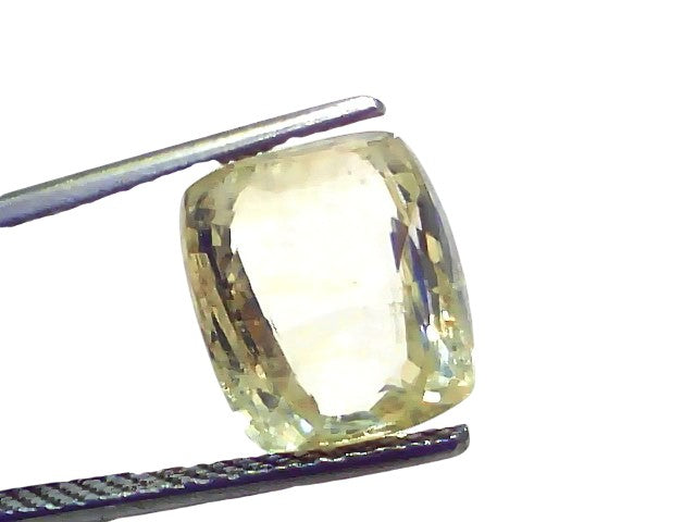7.13 Carat Ceylon Natural Yellow Sapphire Pukhraj, cushion cut, held with tweezers, showcasing its clarity and brilliance.