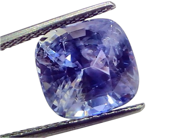 Ceylon blue sapphire gemstone, 9.53 carats, cushion cut, IGI certified, displayed in tweezers against a white background.